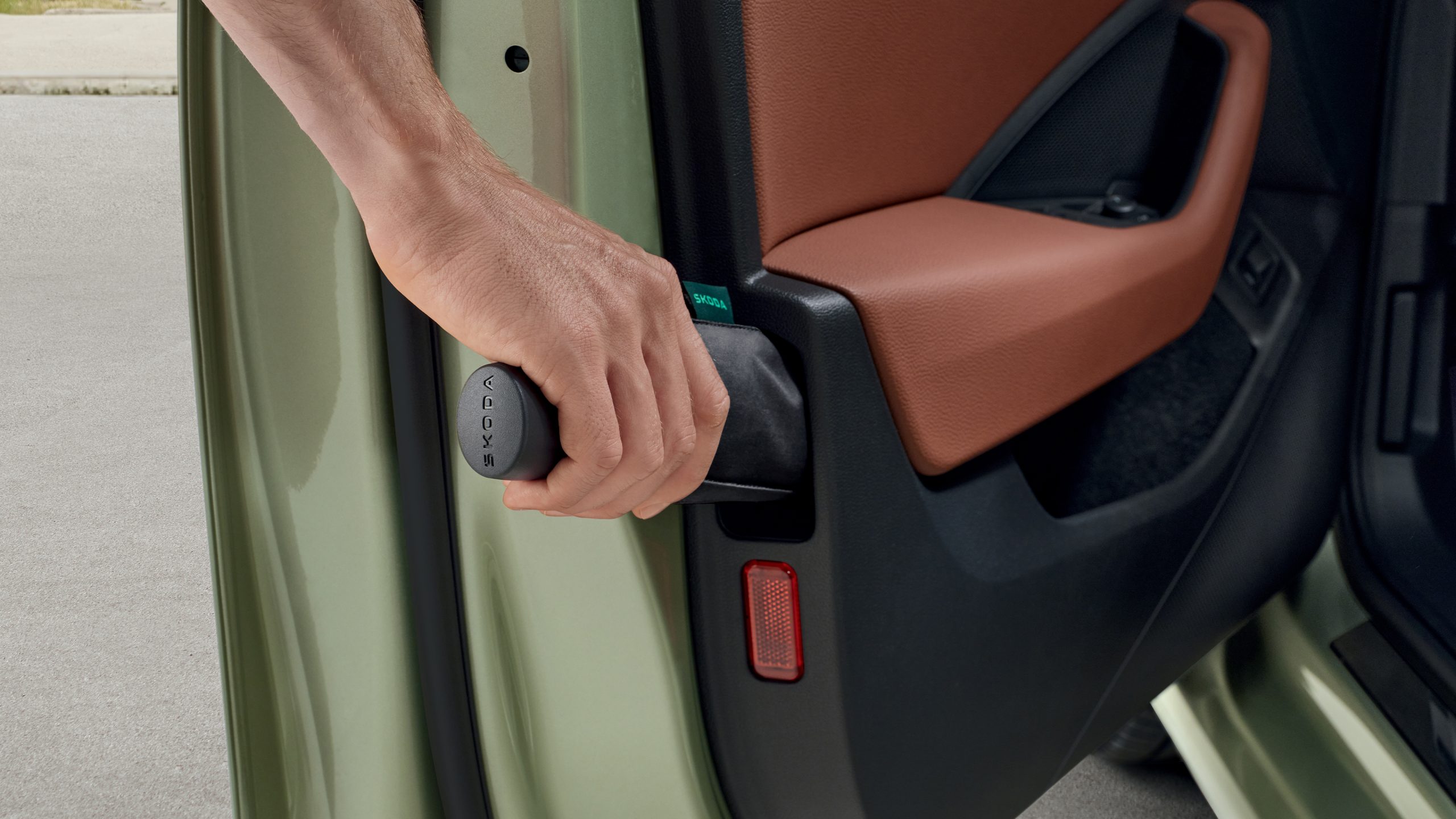 A Škoda driver removes the integrated umbrella from the front door
